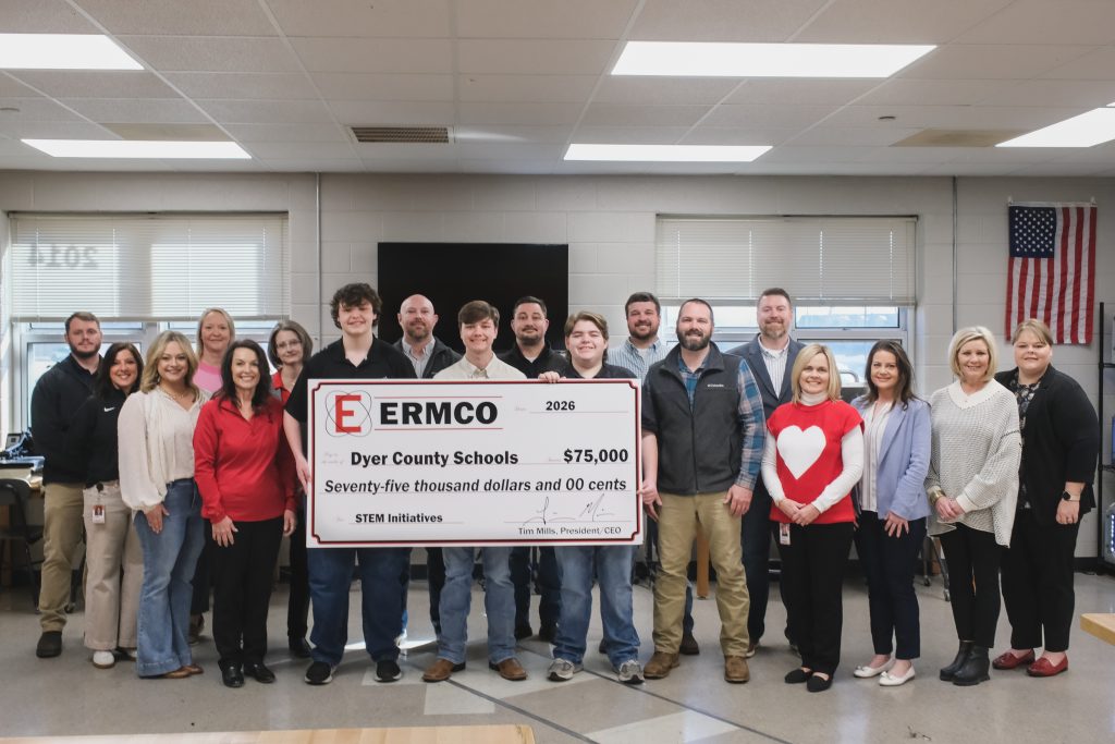 Group of ERMCO representatives and Dyer County Schools staff holding a ceremonial $75,000 donation check for STEM initiatives inside a classroom setting